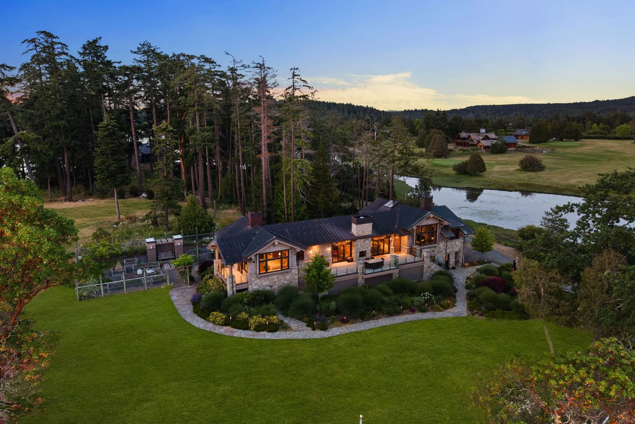 Aerial twilight view of an estate with lit windows, photographed by ACRE Seattle