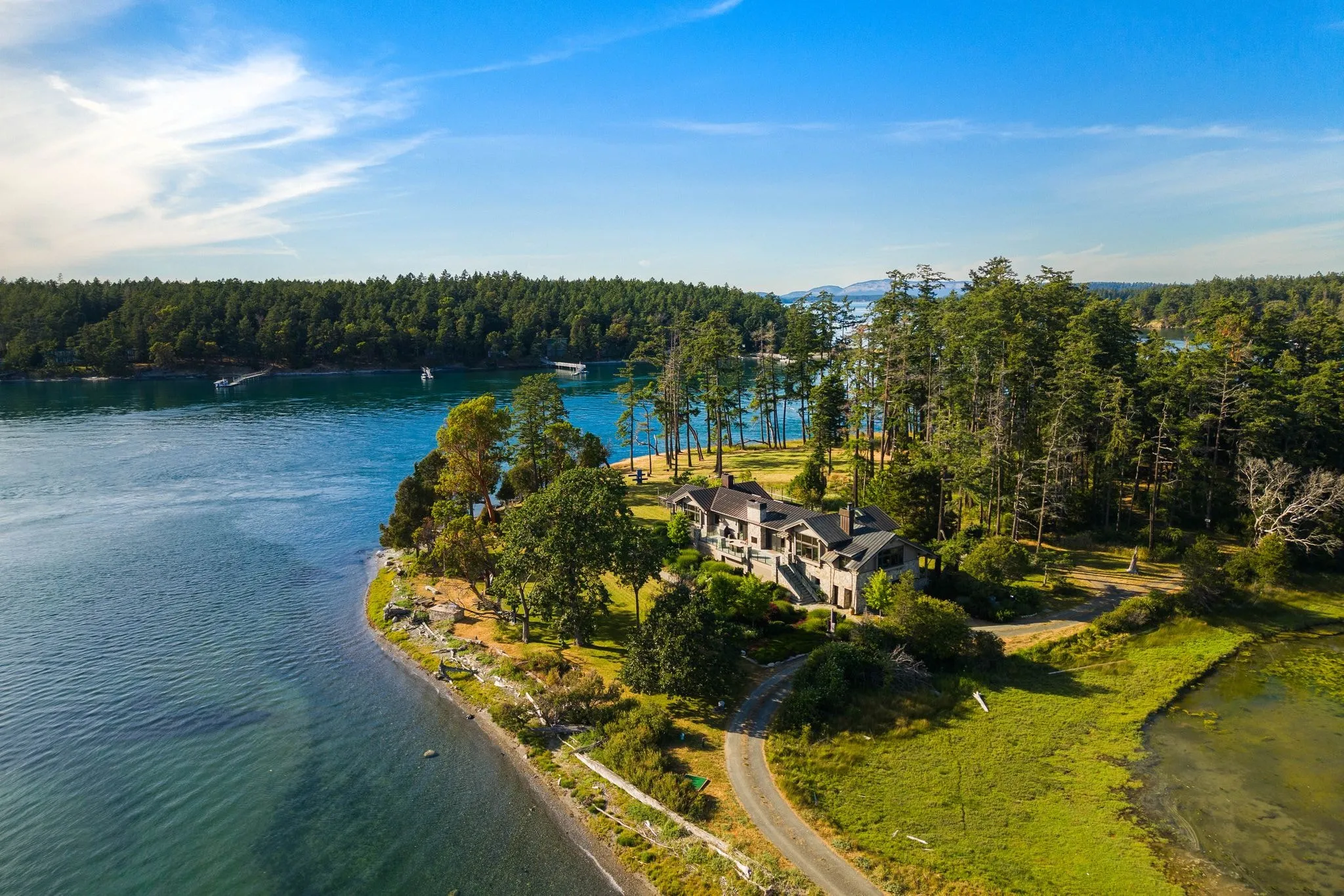 Aerial view of a waterfront property and private dock filmed by ACRE Seattle