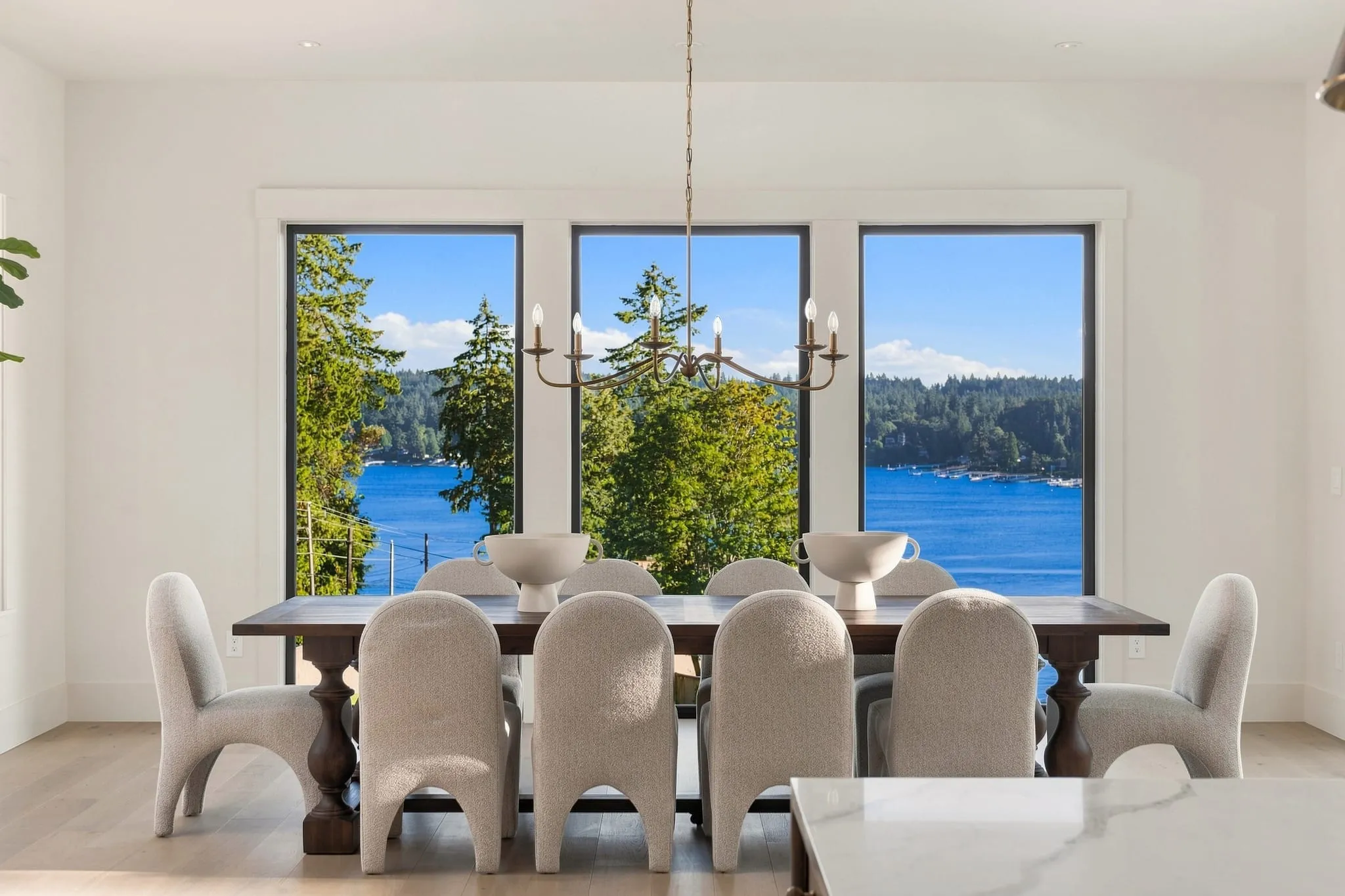 Dining room with sculpted chairs and tall windows looking onto the lake