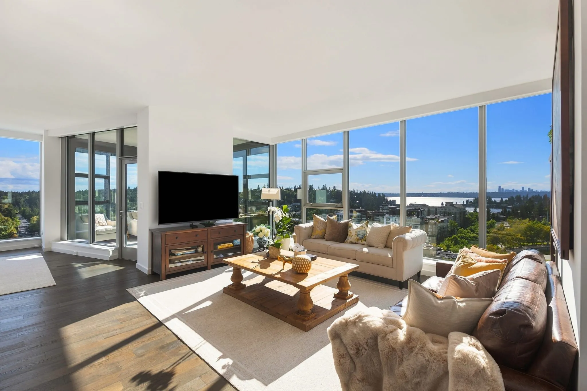 High-rise condo living room with corner window walls and water views