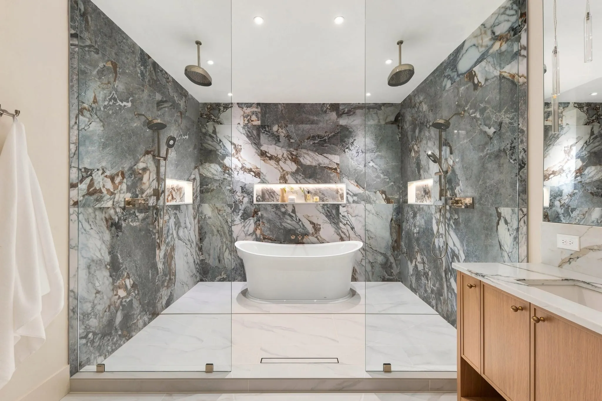 Marble wet room with dual showers and a freestanding tub