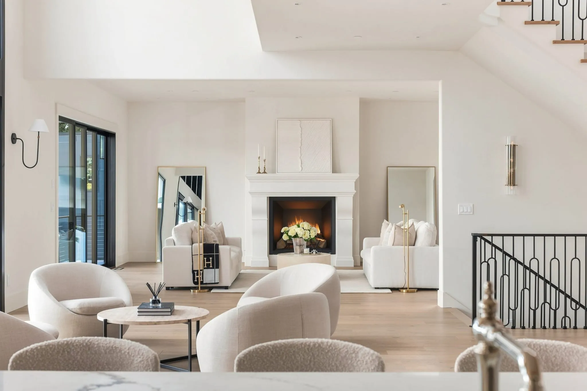 White living room with a fireplace flanked by arched mirrors