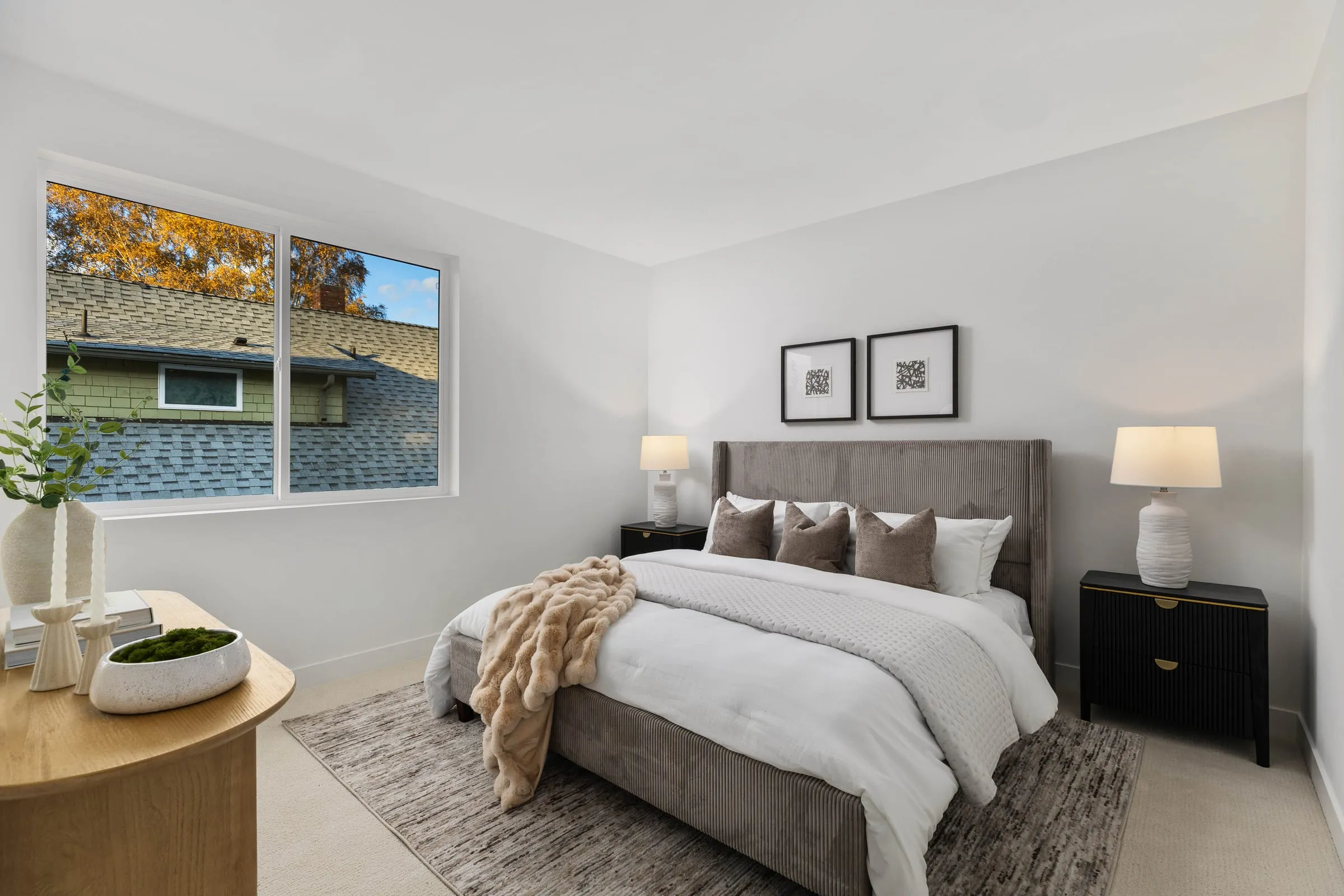 Styled primary bedroom with an upholstered bed, layered throw and paired bedside lamps