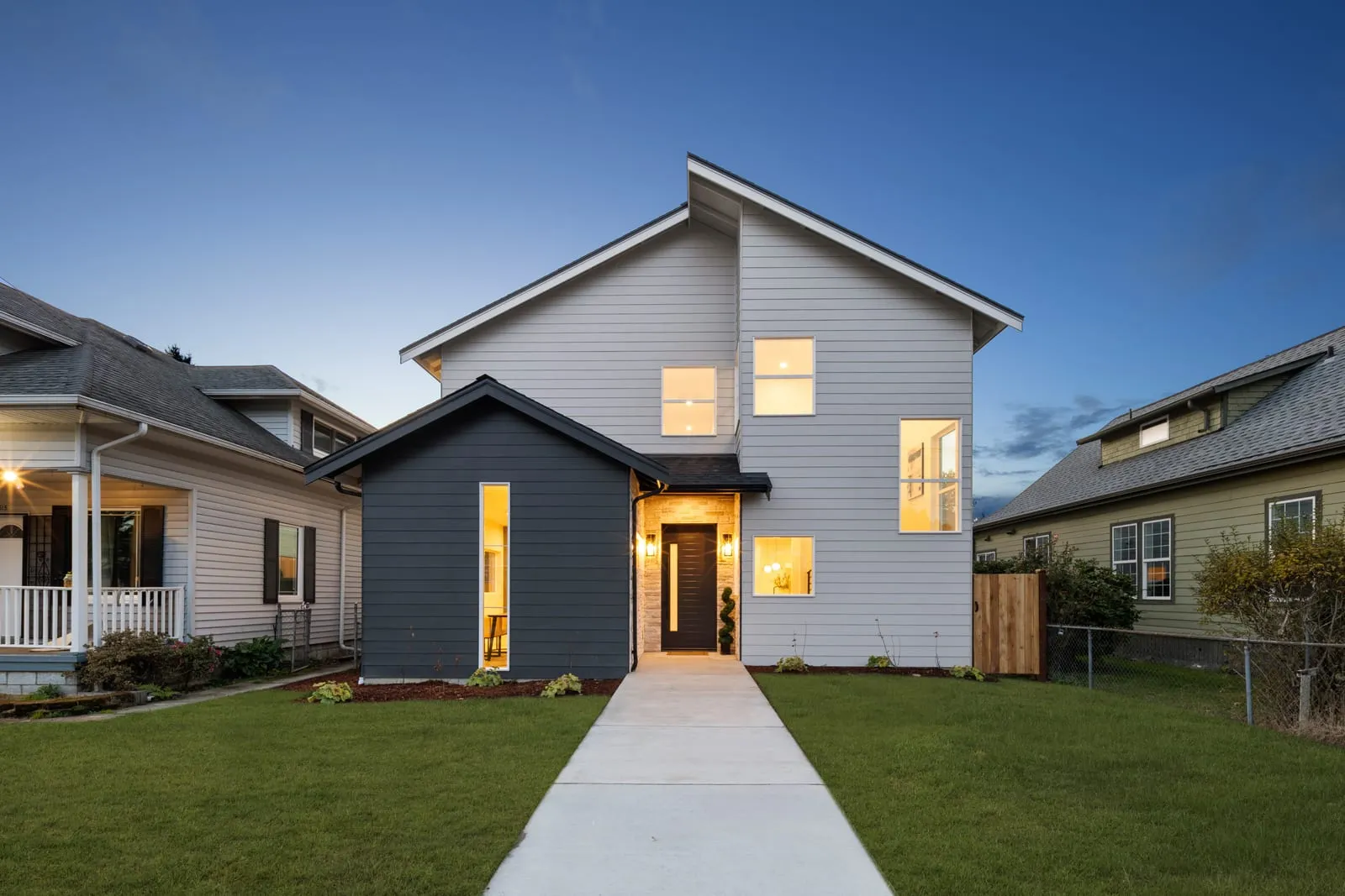 Modern exterior at dusk with a lit walkway to the door